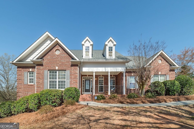 view of front of house featuring brick siding and a porch