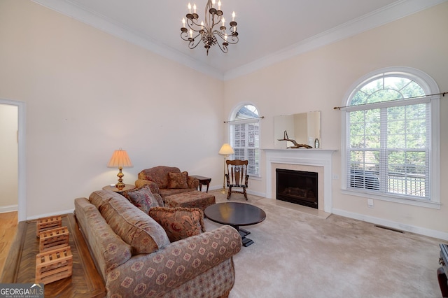 living area with a notable chandelier, a fireplace with flush hearth, baseboards, and ornamental molding