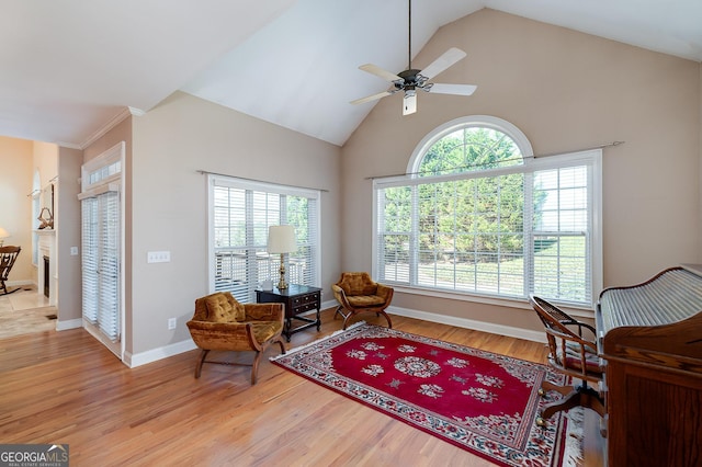 living area featuring baseboards, high vaulted ceiling, light wood-type flooring, and ceiling fan