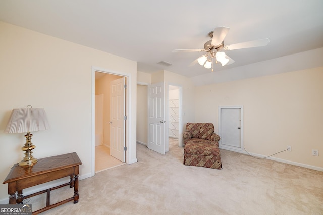 living area with baseboards, a ceiling fan, visible vents, and light carpet