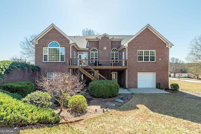 back of house featuring a lawn, a deck, stairway, an attached garage, and brick siding