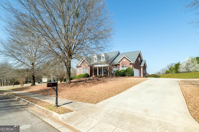 view of front of home featuring brick siding, an attached garage, and driveway