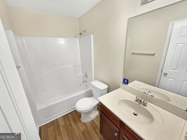 full bath with shower / bathing tub combination, toilet, wood finished floors, and vanity