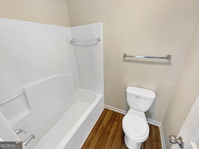 bathroom featuring baseboards, toilet, a bathing tub, wood finished floors, and a shower