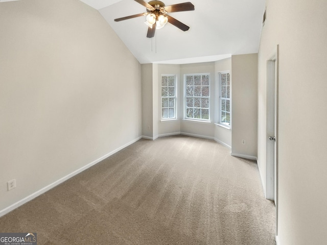 unfurnished room with baseboards, light colored carpet, a ceiling fan, and vaulted ceiling