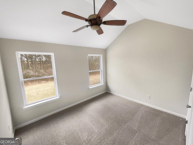 carpeted empty room featuring baseboards, lofted ceiling, and a ceiling fan