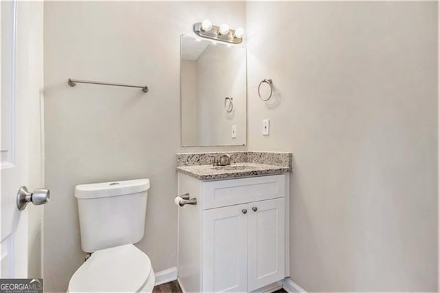 bathroom featuring vanity, toilet, and baseboards