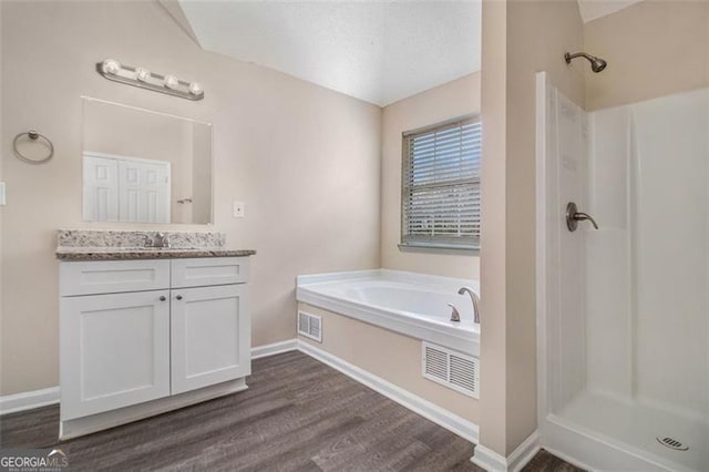 full bathroom featuring vanity, wood finished floors, visible vents, and a stall shower