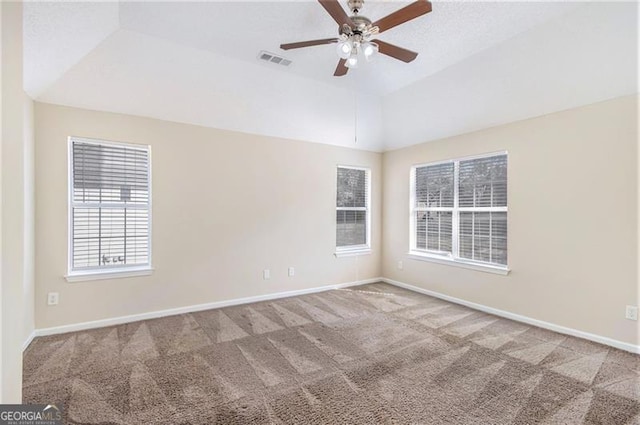 spare room with baseboards, visible vents, carpet floors, ceiling fan, and vaulted ceiling