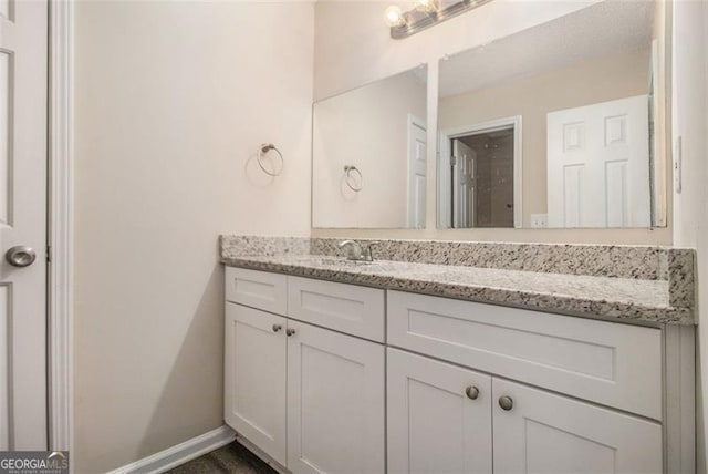 bathroom featuring baseboards and vanity