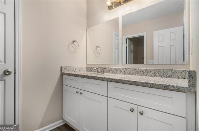 bathroom with baseboards and vanity