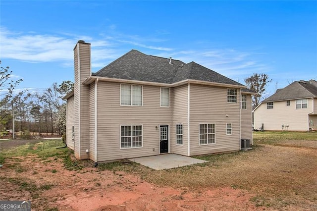 rear view of property featuring a patio, central AC unit, and a chimney