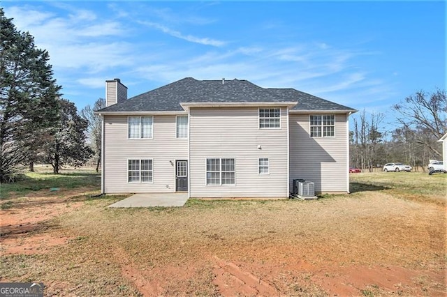 back of property featuring a patio area, a lawn, and a chimney