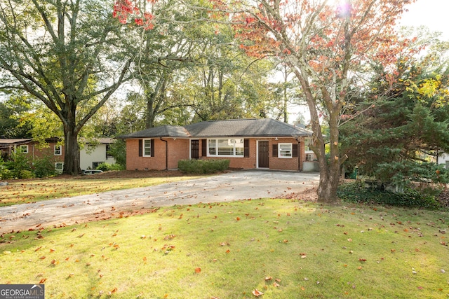 single story home with brick siding, concrete driveway, and a front lawn