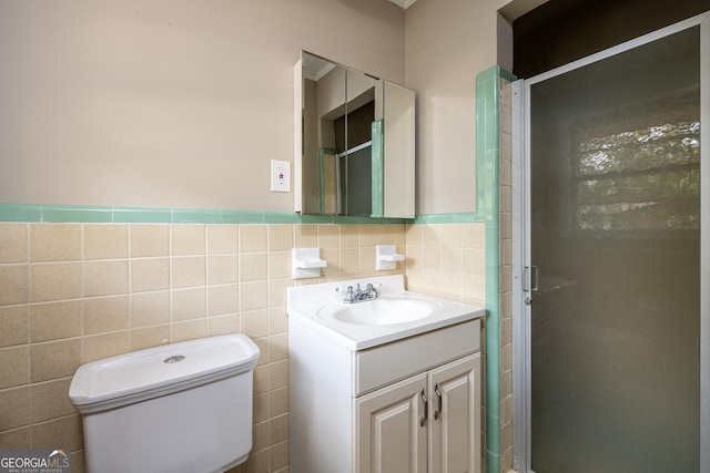 full bath featuring a shower stall, tile walls, toilet, wainscoting, and vanity