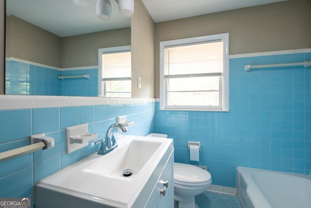 bathroom featuring tile walls, a wainscoted wall, toilet, tile patterned floors, and vanity