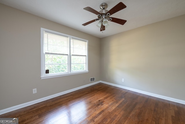 spare room with visible vents, baseboards, ceiling fan, and dark wood-style flooring