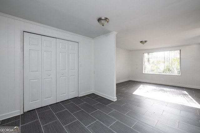 unfurnished bedroom with baseboards, a closet, and ornamental molding