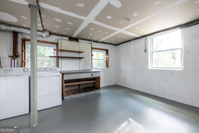 basement featuring concrete block wall and washer and clothes dryer