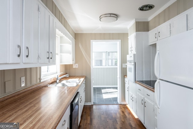 kitchen featuring dark wood-type flooring, ornamental molding, a sink, white appliances, and white cabinets