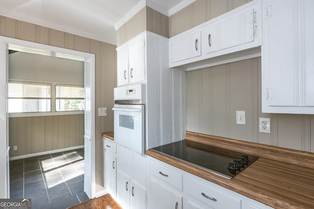 kitchen with white oven, black electric cooktop, and white cabinets