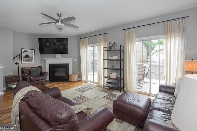 living area featuring a healthy amount of sunlight, wood finished floors, and a ceiling fan