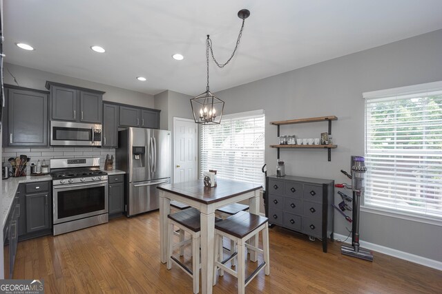 1383 Dolcetto Trce NW Unit 9, Kennesaw, GA 30152 - kitchen with appliances with stainless steel finishes, a chandelier, wood finished floors, tasteful backsplash, and light countertops