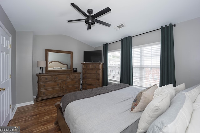 bedroom featuring a ceiling fan, wood finished floors, visible vents, baseboards, and lofted ceiling