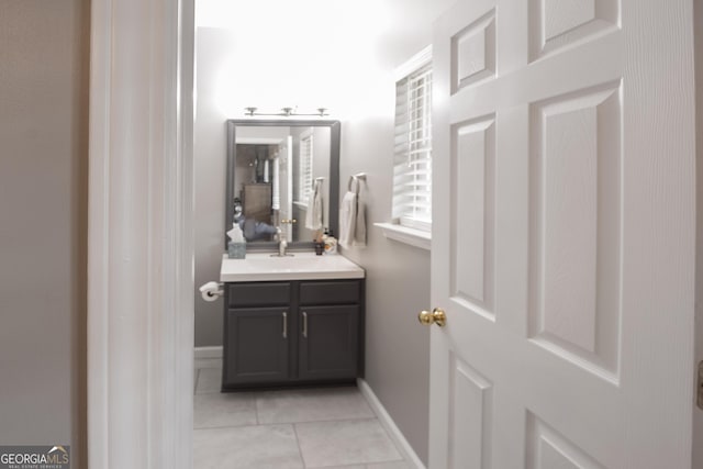 bathroom with tile patterned floors, baseboards, and vanity