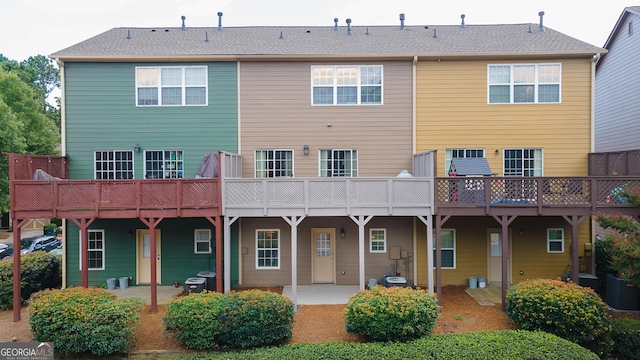 back of property with a deck, a patio area, and central AC