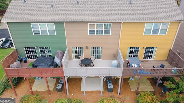 back of house featuring outdoor dining area and a wooden deck