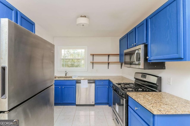 kitchen featuring appliances with stainless steel finishes, blue cabinets, and a sink