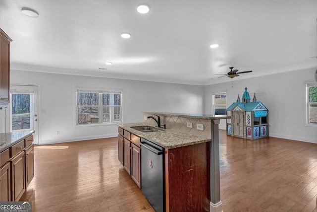 kitchen with stainless steel dishwasher, ceiling fan, light wood finished floors, and a sink