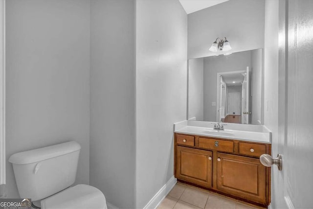 half bathroom featuring vanity, tile patterned floors, toilet, and baseboards