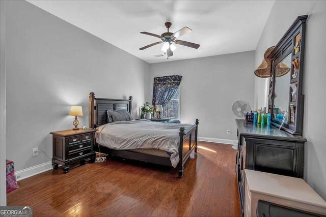 bedroom with dark wood-style floors, visible vents, ceiling fan, and baseboards