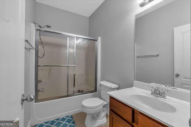 bathroom featuring tile patterned flooring, toilet, vanity, and shower / bath combination with glass door