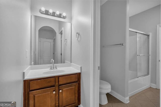 full bath featuring tile patterned floors, toilet, baseboards, bath / shower combo with glass door, and vanity