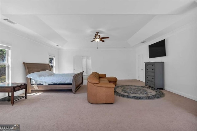 carpeted bedroom with a tray ceiling, baseboards, visible vents, and ceiling fan