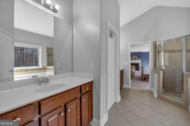 full bathroom with vanity, a fireplace, a shower stall, ensuite bathroom, and tile patterned floors