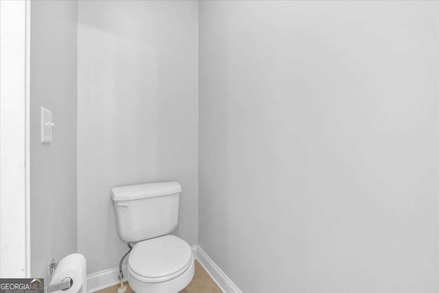 bathroom with toilet and baseboards