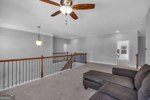 carpeted living area featuring baseboards and ceiling fan