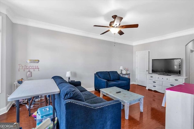 living room featuring wood finished floors, a ceiling fan, baseboards, arched walkways, and crown molding