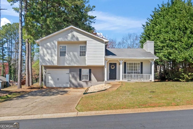 split level home with a front lawn, a porch, concrete driveway, a garage, and a chimney