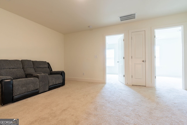 living area featuring visible vents, carpet flooring, and baseboards