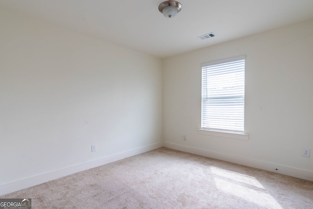 carpeted spare room featuring visible vents and baseboards