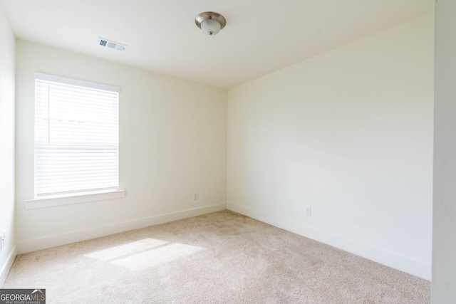 carpeted spare room featuring visible vents and baseboards