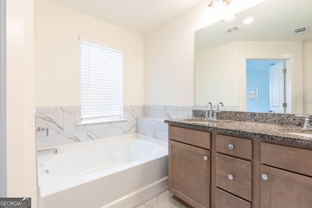 bathroom featuring a sink, visible vents, a bath, and double vanity