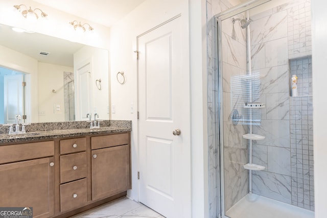 full bathroom with double vanity, marble finish floor, a marble finish shower, and a sink