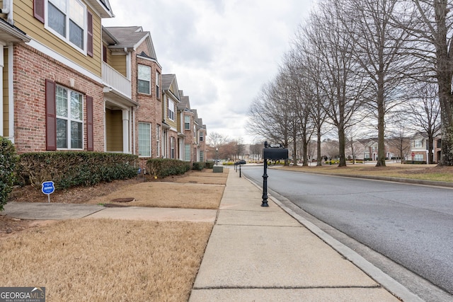 view of road with sidewalks, curbs, and a residential view