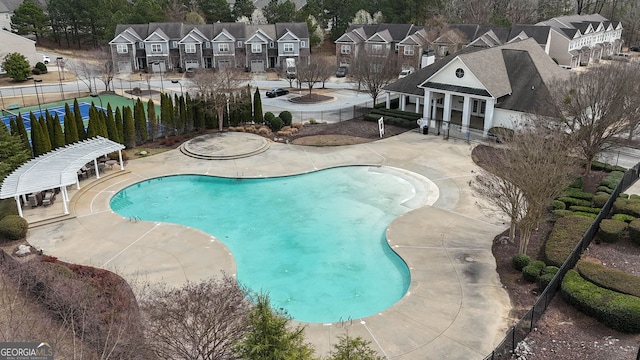 pool featuring a patio area, fence, and a residential view